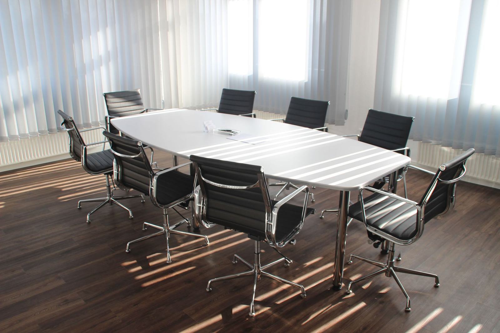 An empty boardroom with morning light across the table